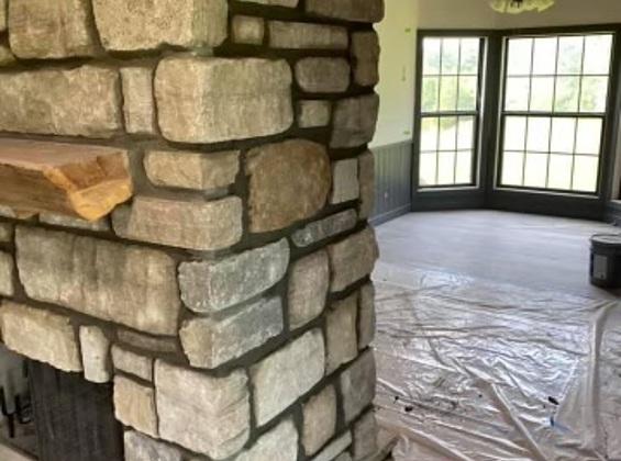 Linked closeup image of side of Stone Fireplace installation with insert