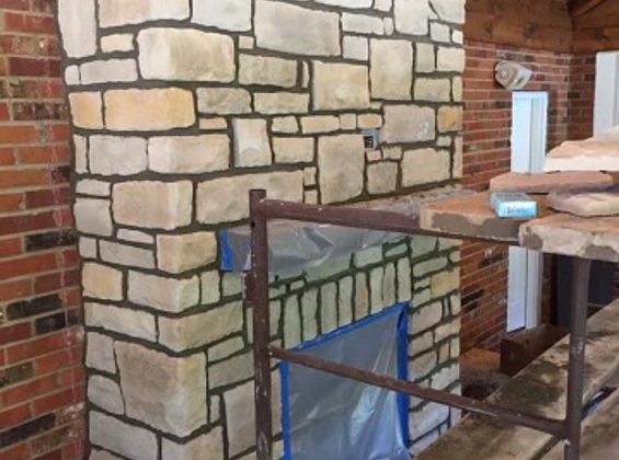 Linked image of stone fireplace installation with scaffolding